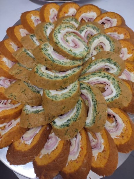 Ein dekorativer Teller mit spiralförmig angeordneten, gefüllten Brötchen.